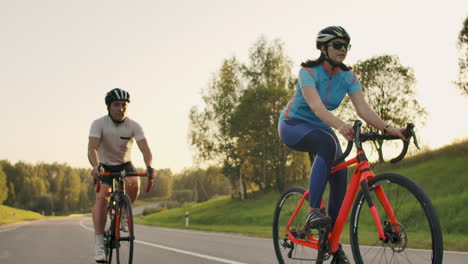 Cyclist-Riding-On-Road-Bike-Rear-View.Cycling-Men-Pedalling-Road-Bicycle-On-City-Park.Tracking-Shot-Of-Cyclist-Rides-On-Road-Bike-At-Sunset-Sun.Cyclist-Athlete-Intensive-Training-On-Bicycle